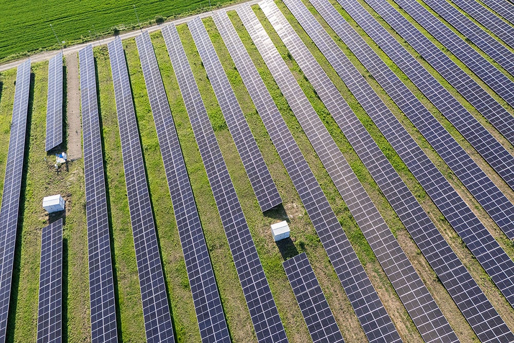 Vue aérienne d'un site solaire ensoleillé et recouvert d'herbe
